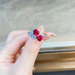 Close-up of double red heart-shaped gemstone ring with micro-pave diamond accents