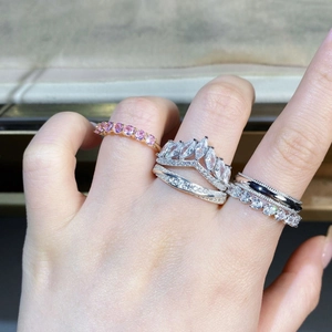 Macro view of stacked S925 silver rings featuring pink stones and crown designs