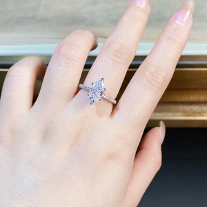 Detailed view of a marquise cut silver ring featuring paved stones on a female hand