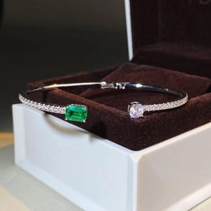 Polished 925 silver open bracelet featuring emerald cut green stone and round zirconia