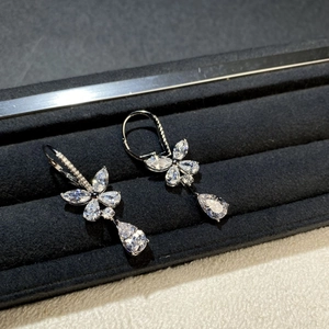 Detail of silver butterfly earrings with marquise and teardrop stones on black velvet