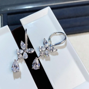 Macro detail of silver flower drop earrings with marquise and teardrop stones