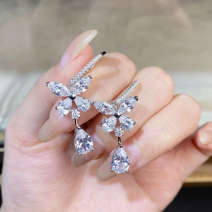 Detailed view of silver butterfly earrings with sparkling crystals held in hand