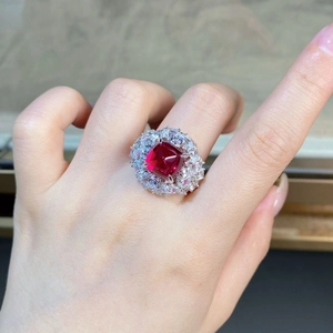 Prachtvoller Ring mit rotem Edelstein und Diamant-Halo an der Hand getragen