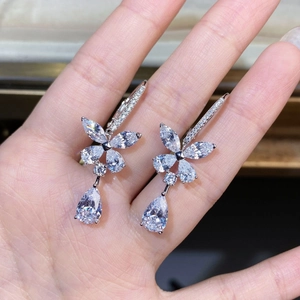 Macro shot of silver butterfly drop earrings with sparkling pear and marquise cut zircons