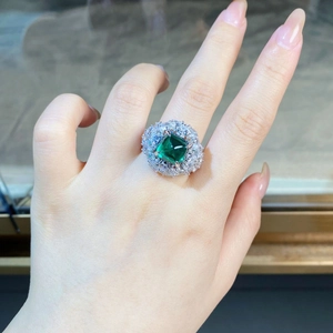 Gros plan sur une bague en argent S925 avec pierre carrée émeraude et halo de diamants