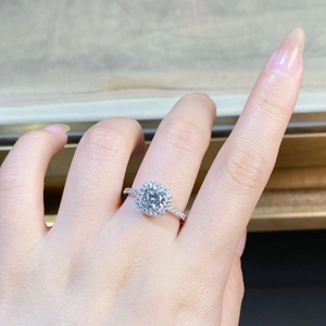 Nahaufnahme eines S925 Silberrings mit 1 Karat Moissanit Halo-Fassung am Finger