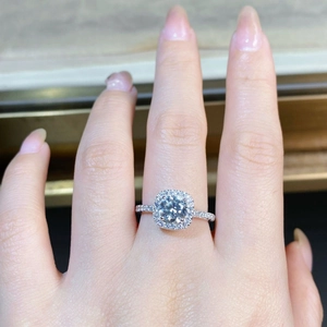 Nahaufnahme eines S925 Sterlingsilber Halo-Rings mit rundem Moissanit am Finger