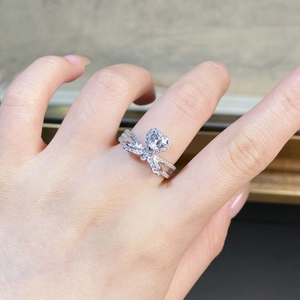 Macro view of heart-cut moissanite ring with bow-shaped micro-pave diamond setting