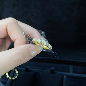 S925 sterling silver ring with white enamel finish and gold plating on a black background