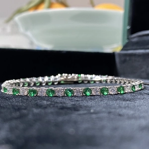 Macro shot of S925 sterling silver tennis bracelet with green and white cubic zirconia