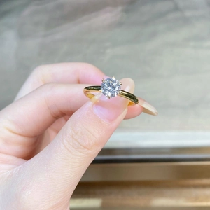 Detailed close-up of a classic six-prong solitaire ring with a sparkling moissanite stone