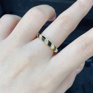 Detail of S925 silver gold-plated ring with black enamel sections and inlaid diamonds