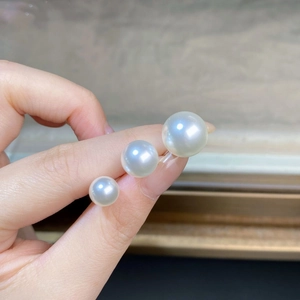 Detail showing three sizes of high-luster S925 silver white pearl earrings held in hand