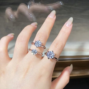 Three classic six-prong moissanite rings on hand in 925 sterling silver finish