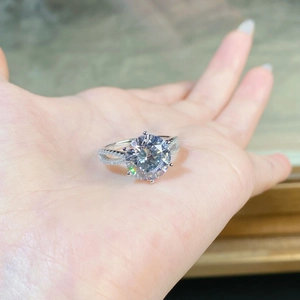 Close-up of a 5-carat round moissanite ring with six-prong setting and pavé twisted band