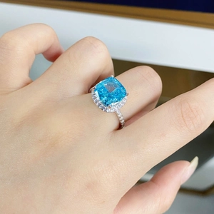 Macro shot of 5 carat radiant cut blue aquamarine silver ring on model finger