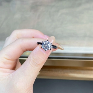 Detailed view of 6-prong moissanite ring showing brilliant cut and silver setting on hand