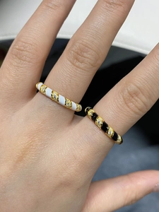 Macro detail of gold plated S925 silver rings with black and white enamel and pave zircons