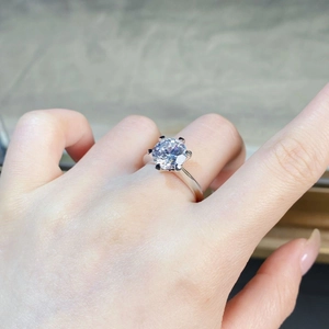 Detail of classic six-prong moissanite ring in 925 silver on woman's finger