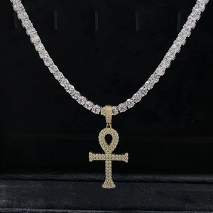 Gros plan sur le pendentif croix Ankh glacé sur une chaîne de tennis argentée