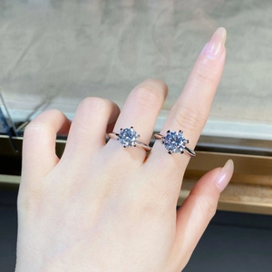 Close-up of two six-prong 925 silver moissanite rings showing different carat sizes