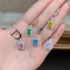 Macro shot of five colors rectangular-cut gemstone stud earrings held by hand