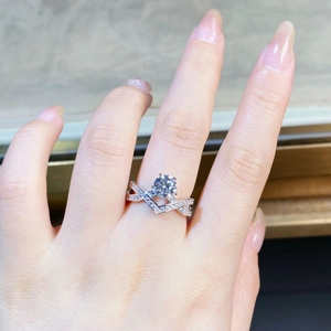 Close-up of V-shaped sterling silver ring with 1ct round moissanite on a model finger
