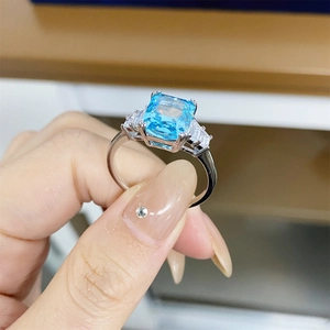 Macro detail of rectangle-cut aquamarine ring with side trapezoid zircon stones