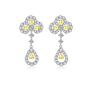 Detail of silver clover earrings with yellow pear-cut stones and pavé diamond halo