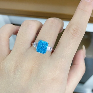 Macro view of a 4-carat rectangle blue gemstone ring with tapered baguette side diamonds