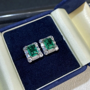Elegant emerald cut silver stud earrings with halo diamonds in a blue velvet gift box