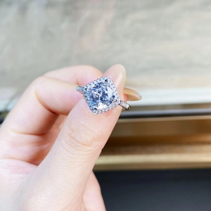 Vue détaillée d'une bague de fiançailles avec diamant taille coussin et halo serti