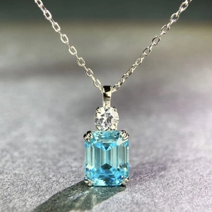 Macro detail of S925 silver necklace featuring emerald cut light blue gemstone pendant
