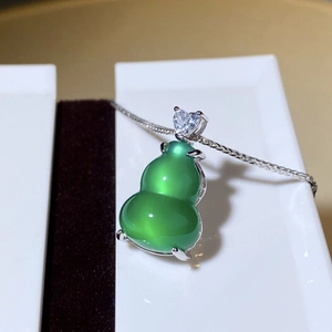 Detailed close-up of a green chalcedony gourd pendant with heart-shaped zircon detail