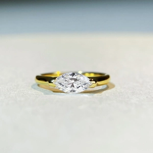 Macro detail of marquise-cut moissanite stone set on a polished gold-plated silver ring