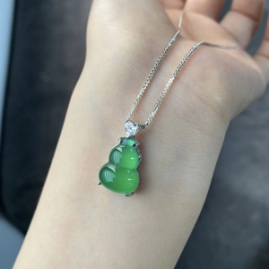 Close-up of translucent green chalcedony gourd pendant with silver chain and heart zircon