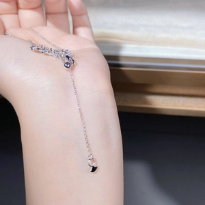 Detailed close-up of 925 sterling silver ginkgo leaf necklace with black inlay on hand