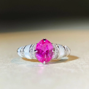 Macro d'une bague avec pierre rose ovale, incrustations de nacre et détails en argent