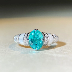 Détail macro d'une bague marquise bleue avec émail blanc et pavage de diamants brillants