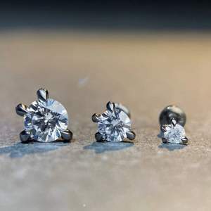 Macro shot of three gunmetal claw-set round cubic zirconia labret studs in various sizes
