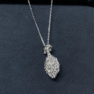 Macro shot of silver oval sunburst flower pendant necklace with shimmering zircon stones