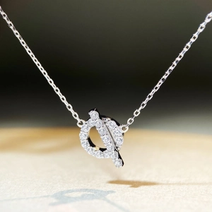 Macro shot of silver OT clasp necklace pendant with pavé set sparkling diamonds
