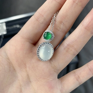 Gros plan d'un pendentif en argent avec deux pierres de jadéite ovales bicolores