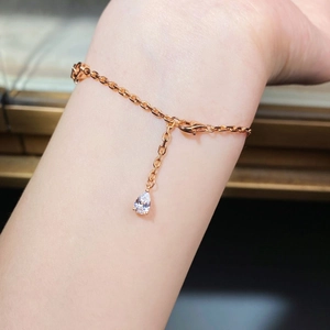 Gros plan détaillé d'un bracelet en chaîne rose doré avec un pendentif en zircone poire au poignet