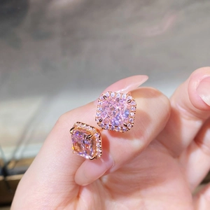 Détail macro de boucles d'oreilles carrées en pierres roses avec halo de diamants