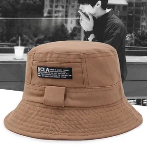 Detail of dark camel cotton bucket hat showing fabric texture and UCLA rectangular label