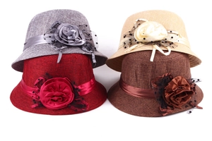 Stack of linen-textured sun hats with floral ribbon and polka dot mesh in various colors
