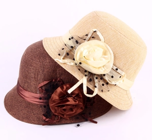 Close-up of linen cloche hats featuring satin flowers and black polka dot mesh veils
