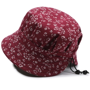 Detail of red floral sun hat featuring adjustable black drawstring and anti-slip toggle